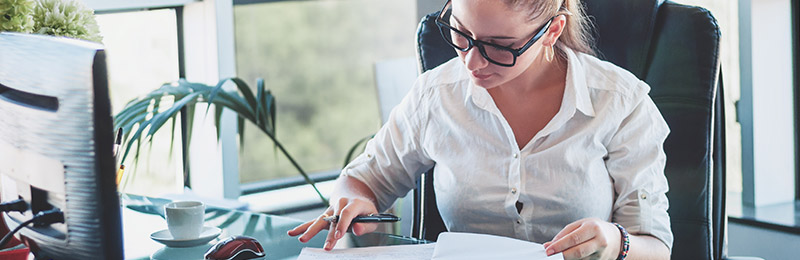 Female entrepreneur working at her desk on calculating the potential market size for her business by using TAM, SAM, and SOM segmentation.